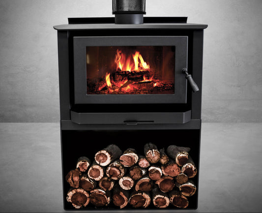 Wood stove with fire burning inside and a pile of wood logs on a gray background
