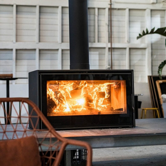 Black Axis I1000 single-sided freestanding wood fireplace firebox showing sleek design and open front view.