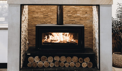 Kemlan Celestial 900 Freestander wood fireplace with fixed handle, showcasing sleek black metal design and large viewing window.