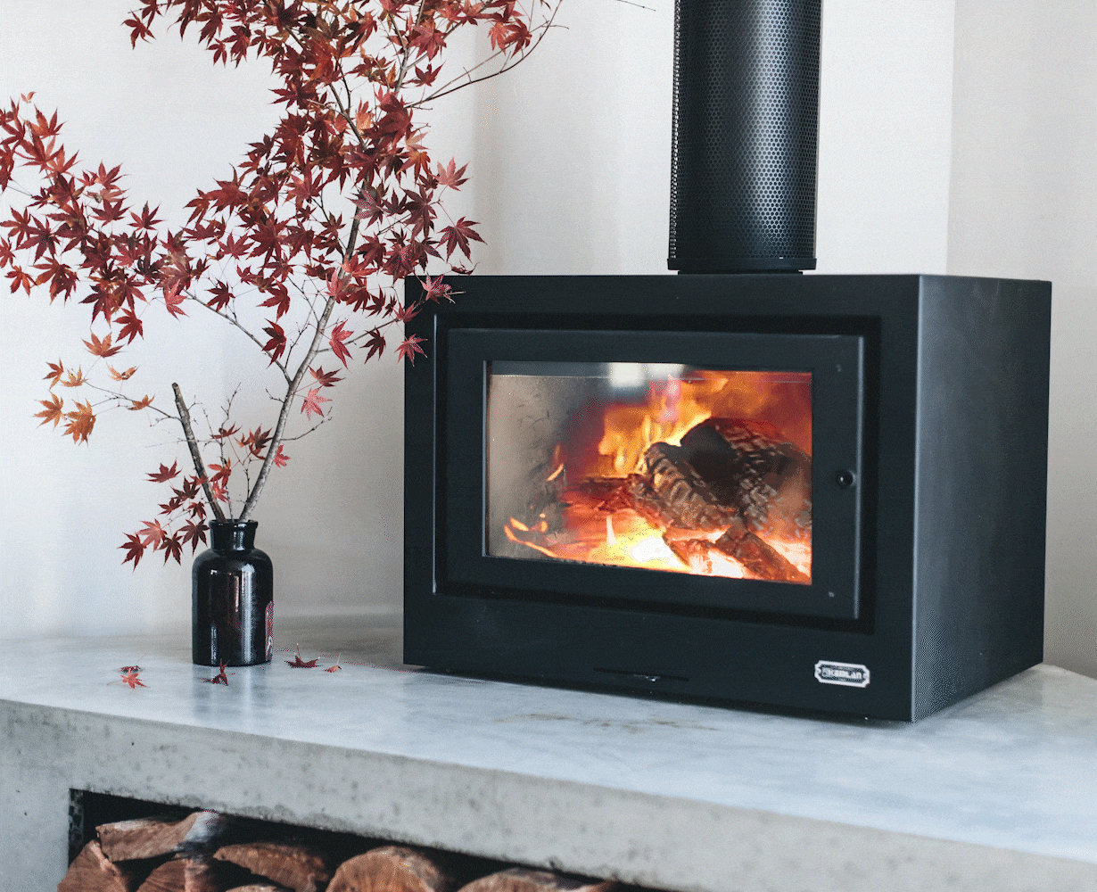 Black Kemlan Cube freestanding wood fireplace with modern cube design, showcasing its sleek and stylish appearance.