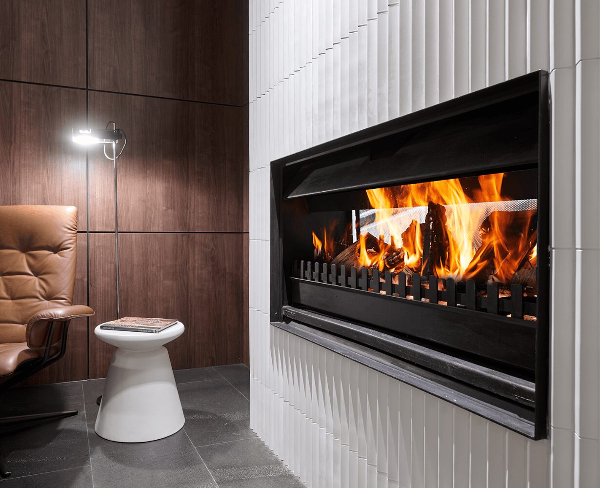 Jetmaster double-sided wood fireplace insert with instructions, showcasing a sleek, modern design in a warm, inviting setting.