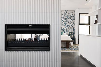Jetmaster double-sided wood fireplace with instruction manual, featuring sleek design and viewing windows for both sides.