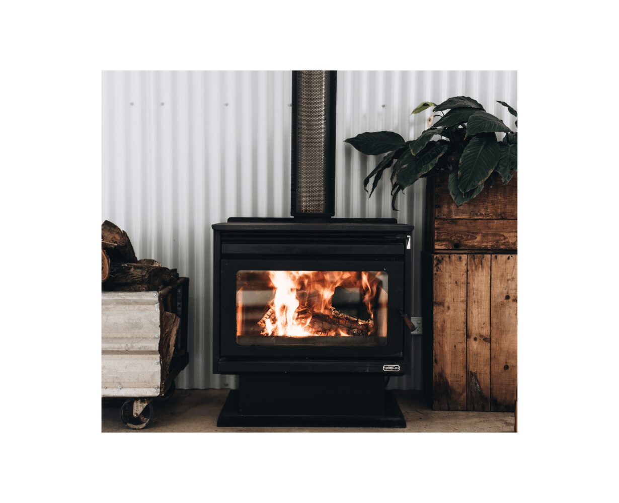Kemlan XL Freestander wood fireplace in black with built-in fan, showcasing its sleek design and functional features.